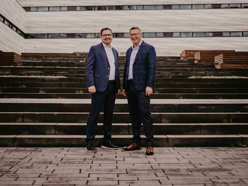 The two founders in front of the building